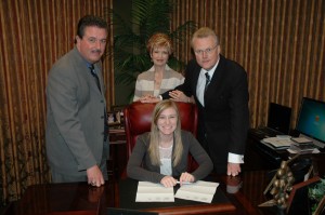 Tara Hill, seated, signs with SpiritSound. Standing left to right are Larry Horrell, Paula Hil and Tim Hill.