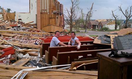 Two men take a break on one of Empire Baptist Church's red pews, some of the few items left untouched by the EF5 tornado that destroyed the church's building and much of Joplin, Mo., Sunday, May 22.